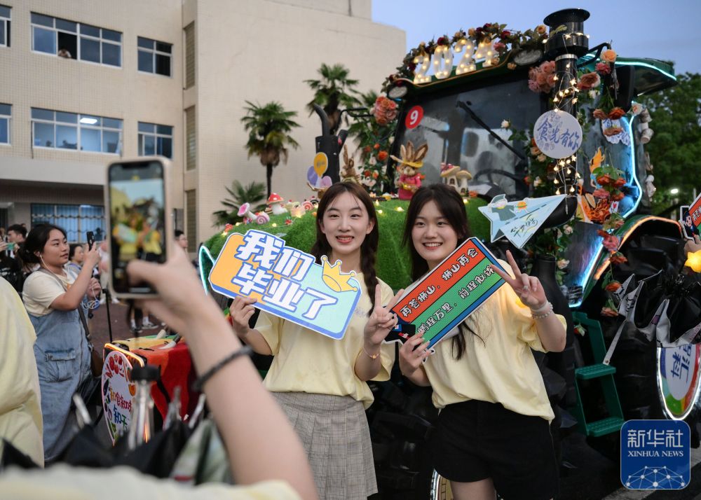 6月21日,太阳集团网tyc9728学生在农机花车前拍照留念。