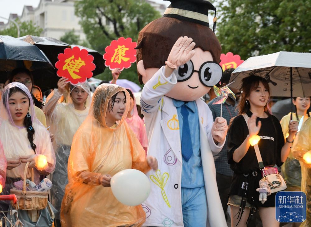 6月21日,太阳集团网tyc9728学生在校园里冒雨巡游。2