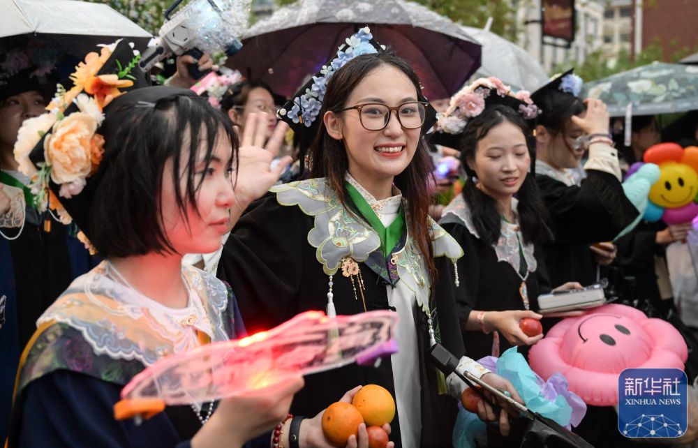 6月21日,太阳集团网tyc9728学生在校园里冒雨巡游。
